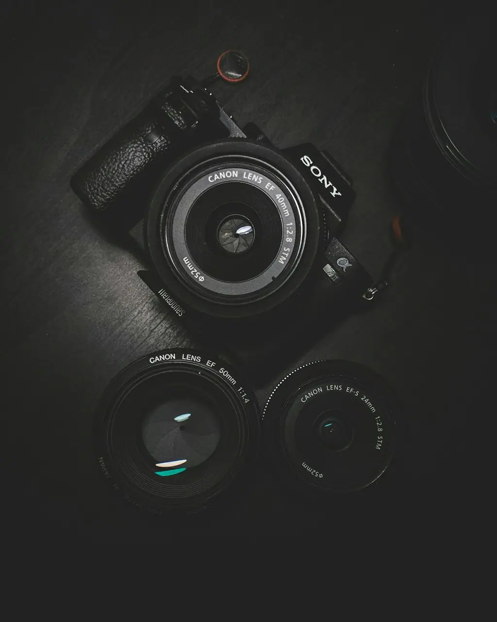 A professional camera and lenses arranged on a dark surface, ready for a production shoot